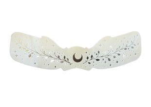 The Freckle Tattoos Silver Moon is a white decorative barrette featuring a silver crescent moon centrepiece, leaf and branch designs, and freckle-like star accents etched or cut into the surface.