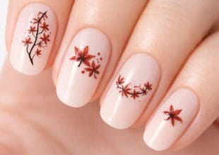 A close-up of a hand with pale pink nails, each decorated with intricate red and black floral designs resembling cherry blossoms. The artwork is delicate, with different floral patterns on each nail.